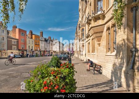 OXFORD CITY ENGLAND BALLIOL COLLEGE AUF DER RECHTEN SEITE IN BREIT STRASSE UND REIHE VON FARBIGEN HÄUSERN BLUMEN UND GESCHÄFTE IN SOMMER Stockfoto