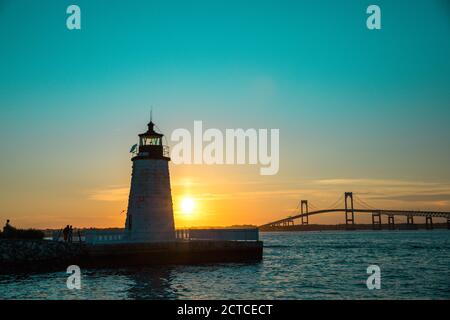 Sonnenuntergang über Newport Harbor Lighthouse mit Brücke und buntem Himmel Stockfoto