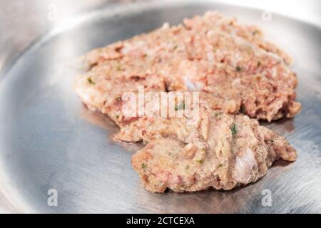 Nahaufnahme der Futterschüssel mit rohem, gemahlenem putenfleisch, inklusive Rücken, Nacken, Leber und Herz. Katzenschale aus Edelstahl. Rohkost Ernährung für Haustiere. Stockfoto