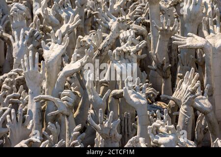 Eine Nahaufnahme der Hände, die aus der Hölle am Weißen Tempel (Wat Rong Khun) in Chiang Rai, Thailand, ragen. Stockfoto