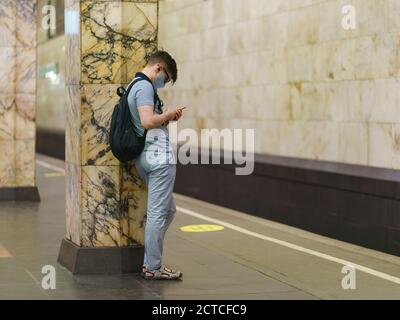 Moskau, Russland - 6. Juli 2020: Moskauer U-Bahn-Station Avtozawodskaya in der Sommerzeit. Junger Mann mit Schutzmaske und wartet auf den Zug. Stockfoto