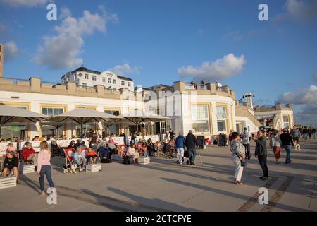 Touristen sitzen in Liegestühlen vor Ria's Beach Cafe an der Strandpromenade von Borkum Island, Friesland, Niedersachsen, Deutschland, Europa. Stockfoto