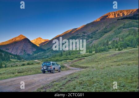 Geländewagen auf Alpine Loop in der Nähe von Cinnamon Pass, Cinnamon Mtn in der Ferne, Sonnenaufgang, San Juan Mountains, Colorado, USA Stockfoto