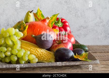 Herbstfrüchte und Gemüse auf grauem Hintergrund Stockfoto