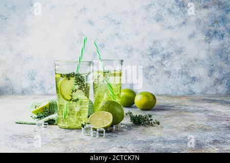 Zwei Gläser mit Limonade mit Thymian und Eis auf hellem Hintergrund. Erfrischende Sommer hausgemachte alkoholische oder alkoholfreie Cocktails oder Detox Infuse Stockfoto