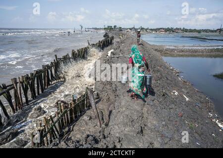 Westbengalen, Indien. September 2017. Eine einheimische Frau geht entlang der schlammigen Böschung auf Sagar Island auf ihrem Weg, um Garnelen zu fischen. Mit dem Salzgehalt des Wassers haben Bewohner und Bauern die Reiszucht zugunsten von Garnelen aufgegeben. Kredit: Supratim Bhattacharjee/ZUMA Wire/Alamy Live Nachrichten Stockfoto