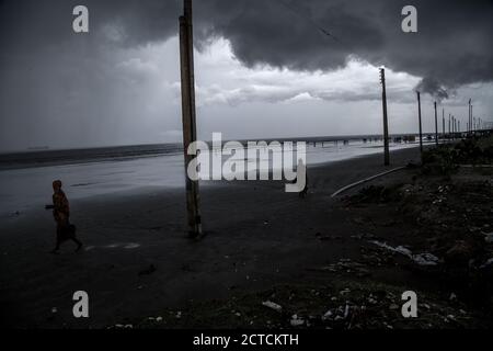 Westbengalen, Indien. August 2018. Die Menschen laufen entlang der Küste, während graue Monsunwolken über Sagar Island in den Sundarbans schweben. Kredit: Supratim Bhattacharjee/ZUMA Wire/Alamy Live Nachrichten Stockfoto