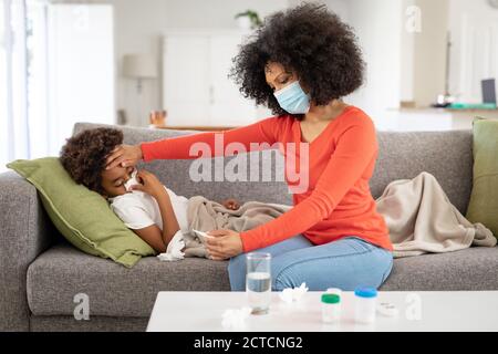 Mutter kümmert sich zu Hause um ihren kranken Sohn Stockfoto