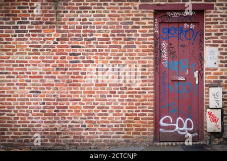 LILLE, FRANKREICH - 18. Juli 2013. Ziegelwand und Tür mit Graffiti-Schrift, ideal für urbane Grunge Hintergrund oder Vorlage Stockfoto