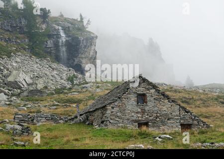 Traditionelles Bauernhaus aus Felsbrocken vor Ort, Schwarzi Balma, Wallis, Schweiz Stockfoto