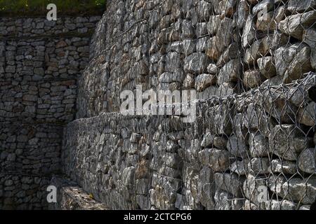 Gabionen. Mit Granitabfällen gefüllte Stahlnetze schützen den Boden vor Verrutschen. Stockfoto