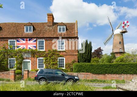 QUAINTON, Großbritannien - 15. Mai 2020. Britische Dorfszene in Buckinghamshire, mit Dorfgrün, britische Flagge auf einem Haus und einer funktionierenden Windmühle Stockfoto