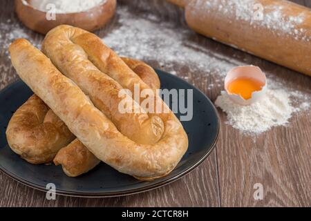 Traditionelles türkisches Borek oder türkisches Gebäck mit Hackfleisch, Käse und Spinat auf Holzgrund. Stockfoto