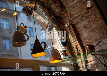 Die Lichter sind aus verschiedenen Tassen, die am Fenster hängen. Stockfoto
