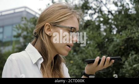 Frau trägt eine Brille mit einem Smartphone Spracherkennung func Stockfoto