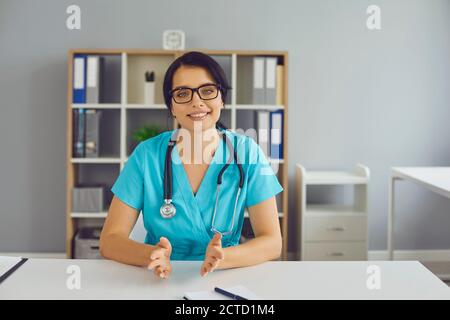 Junger Arzt am Schreibtisch sitzen und Beratung für den Patienten Während eines Online-Videoanrufs Stockfoto