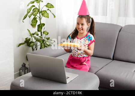 Junges Mädchen feiert Geburtstag während Quarantäne. Virtuelle Geburtstagsfeier online mit ihrem Freund oder Liebhaber. Videoanruf auf Laptop. Soziale Distanz, bleiben Stockfoto