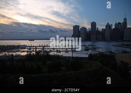 Der Sonnenuntergang über Downtown Manhattan und dem Pier Stockfoto