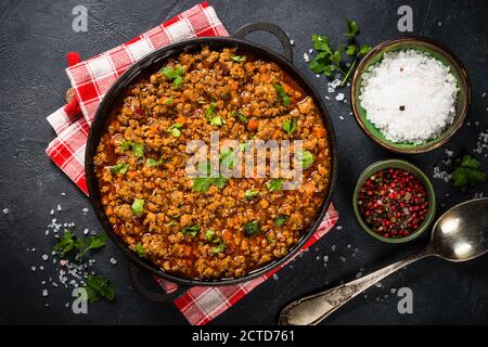 Bolognese steht in Eisenplatte am schwarzen Tisch. Stockfoto