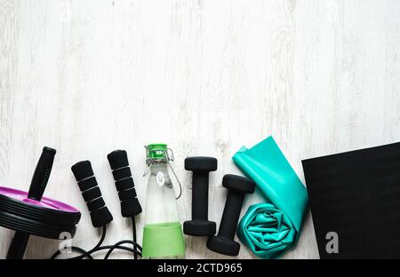 Über Ansicht von vielen Heimtrainingssachen auf Heimraum weißem Holzboden. Viel Kopierspeicher. Gesundes Fit-Life-Konzept. Unterer Rand, viel Platz. Stockfoto