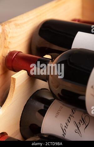 Flaschen Rotwein liegen flach in einer Holzkiste. Stockfoto