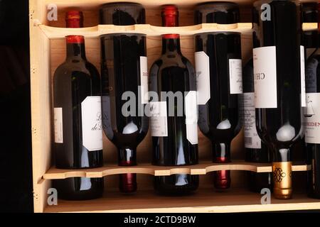 Flaschen Rotwein liegen flach in einer Holzkiste. Stockfoto