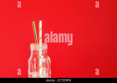 Keine Verschwendung. Papier Recycable trinken Cocktail Party Strohhalme in Glas vintage Flasche auf rotem Hintergrund. Stockfoto