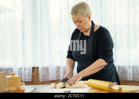 Frau mittleren Alters macht hausgemachte Kekse und Gebäck Scheiben Teig Stockfoto