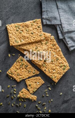 Das knusprige Brot mit Kürbiskernen. Knackebrot auf schwarzem Tisch. Draufsicht. Stockfoto