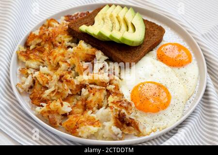 Leckere hausgemachte gebratene Hashbrowns und Eier auf einem Teller, Blick aus der unteren Ecke. Nahaufnahme. Stockfoto