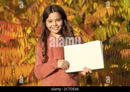 Kleines Kind lesen Herbstlaub Hintergrund. Kleines Kind lernen Sie im Herbst Park. Kid Studie mit Buch. Herbst Literatur konzept. Studiere weiter. Kleines Mädchen Buch lesen im Herbst Tag. Stockfoto