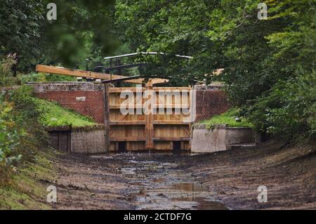 Neue Schleusentore, aber kein Wasser im Basingstoke Canal bei Pirbright in Surrey Stockfoto