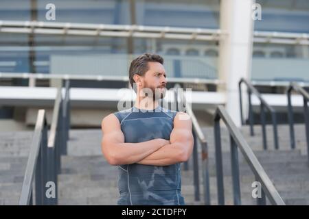 Mann muskulösen Fitness-Trainer wartet auf Treppen Stadion Eingang Hintergrund. Stockfoto