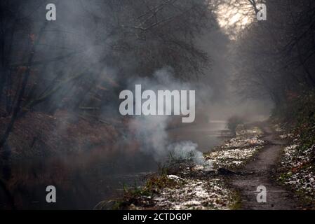 Rauch driftet nach oben von einem Feuer auf dem Schleppturm entlang Der schöne Basingstoke Canal in Deepcut Stockfoto