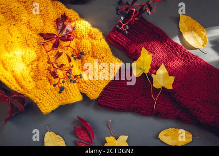 Herbstkleidung. Pullover in Gelb und Burgunderrot mit Blättern und Beeren überzogen. Flach liegend, Draufsicht Stockfoto