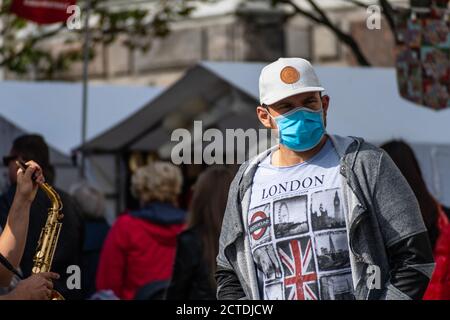 Mann trägt Maske mit London, UK Flagge T-Shirt. Boris Johnson kündigte neue Coronavirus-, Covid-Beschränkungen und Maßnahmen für England an Stockfoto