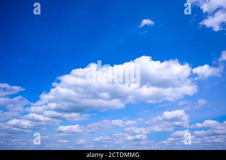 Tiefblauer Himmel mit Wolken und Silhouetten fliegender Vögel, trübes Hintergrundfoto in der Skyscape Stockfoto