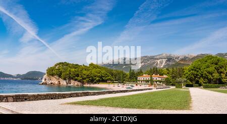 Malerisches Panorama von Milocer Plaza der luxuriöse Strand des Königs in Przno Dorf, Montenegro. Winziger Strand mit massiven Bergen im Hintergrund. Stockfoto