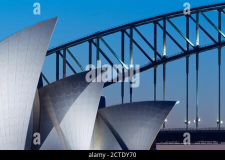 Architektonische Details vom Sydney Opera House und der Sydney Harbour Bridge in Sydney, Australien, bei Sonnenuntergang/Dämmerung. Stockfoto