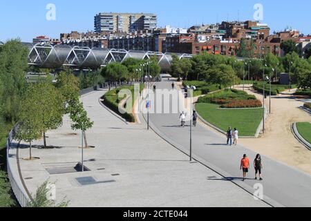 Mehrere Personen, die mit einer Gesichtsmaske im linearen Park des Flusses Madrid (Spanien) spazieren. / Ana Bornay Stockfoto