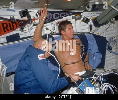 (24. November-1. Dezember 1991) - - - Astronaut F. Story Musgrave (links), Mission Specialist, unterstützt Astronaut Terence T. (Tom) Henricks, Mission Specialist, mit einem ausführlichen Ergänzenden Ziel (DSO) mit unteren Körper negative Druck. Stockfoto