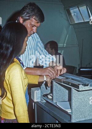 1975 - ein vietnamesischer Flüchtling wird durch eine Einwanderung und Einbürgerung offizielle bei ihrer Ankunft in eine temporäre Wohnanlage weist Fingerabdrücke auf. Stockfoto