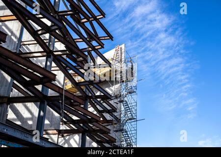 Teilbau eines mehrstufigen Industriegebäudes. Stahlrahmen/Metallbalken sichtbar mit Gehwegen und Leitern. Eckansicht. Stockfoto