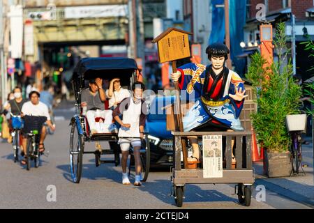 Geschäftsanläufe für Rikscha-Dienste in Asakusa, Tokio, Japan in der Nähe des Kaminarimon-Tores, wobei der Servicemitarbeiter einen Mundschutz trägt Stockfoto