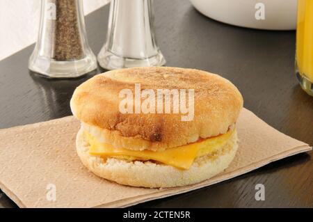 Ein englischer Muffin mit Schinken, Ei, Käse und einem Glas Orangensaft Stockfoto