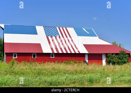 Sabula, Iowa, USA. Eine alte Veteranenscheune mit einem patriotischen rot, weiß und blau Dach komplett mit einer amerikanischen Flagge. Stockfoto
