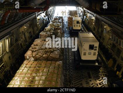 Loadmasters, der 15. Airlift Squadron von der Joint Base Charleston, S.C. zugewiesen wurde, beladen ein mobiles Feldkrankenhaus von einem C-17 Globemaster III am Norman Manley International Airport in Kingston, Jamaika, 19. September 2020. Die dem 15. Airlift Squadron zugeordnete Luftbesatzung transportierte das große mobile Feldkrankenhaus von Charleston nach Kingston, wo es an Gesundheitsdienstleister gespendet und zur Unterstützung der anhaltenden Reaktion des karibischen Landes auf die COVID-19-Pandemie verwendet wird. Die Spende, die im Namen des amerikanischen Volkes gemacht wurde, kostete 753,000 Dollar und wurde als Teil des U.S. Southern Command gekauft Stockfoto