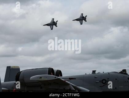 Ein A-10C Thunderbolt II, der dem A-10 Demonstrationsteam zugewiesen wurde, sitzt auf der Fluglinie während einer Flugshow, die im Naval Air Station Oceana, Virginia, September 19 2020 stattfindet. Zwei F/A 18 Super Hornets auf Basis von NAS Oceana werden während der NAS Oceana Air Show bei einer Demonstration der Luftleistung beobachtet. (USA Luftwaffe Foto von Senior Airman Kristine Legate) Stockfoto