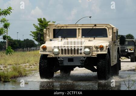 ORLANDO, Florida - US Army Reserve Soldaten von der Headquarters and Headquarters Company, 143d Sustainment Command (Expeditionary), fahren ein hochmobiles Mehrzweck-Fahrzeug mit Rädern durch Wasser während des ersten Teils des Fahrertrainings am 11. Juli 2020. Fahrertraining hilft Soldaten auf verschiedenen Army Reserve Fahrzeug-Systeme vertraut zu machen, um Einheit Bereitschaft zu verbessern. Stockfoto