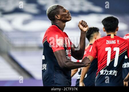 Der kamerunische Fußballspieler John Mary aus Shenzhen F.C., links, feiert nach einem Tor im vierten Spielrunde des chinesischen Super LEAG 2020 Stockfoto